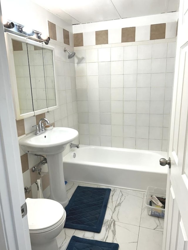 full bath featuring marble finish floor, toilet, and bathing tub / shower combination