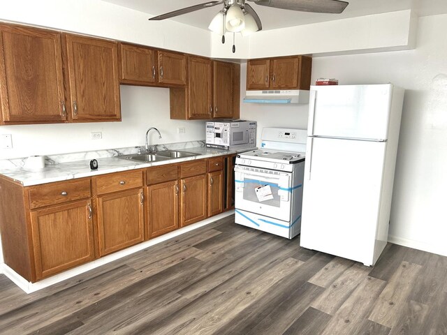 kitchen featuring a ceiling fan, a sink, light countertops, under cabinet range hood, and white appliances