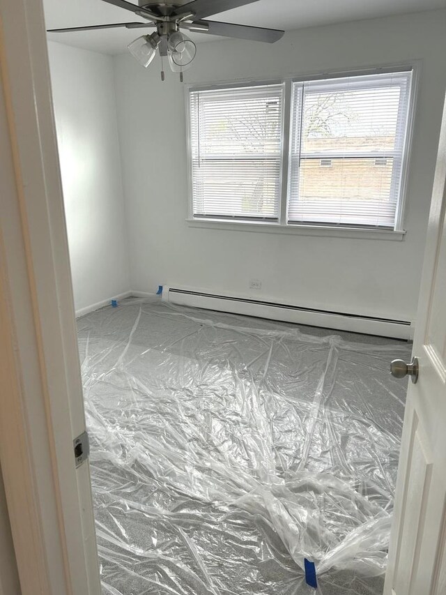 spare room with ceiling fan and baseboard heating