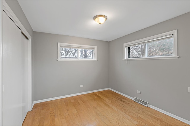 2724 W 96th Pl, Evergreen Park, IL 60805 - unfurnished bedroom with visible vents, multiple windows, light wood finished floors, and a closet