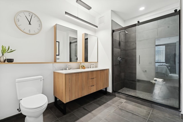 bathroom with a stall shower, toilet, double vanity, and tile patterned flooring