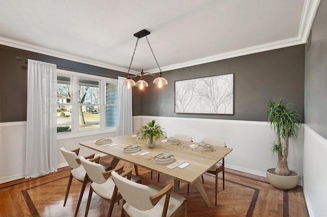 dining space with crown molding and wood finished floors
