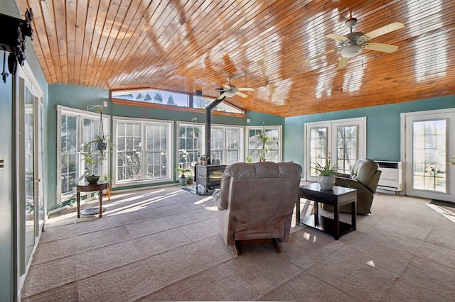 sunroom featuring lofted ceiling, wooden ceiling, french doors, and a wood stove