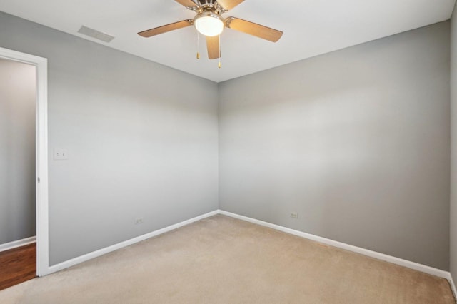 empty room with baseboards, a ceiling fan, visible vents, and light colored carpet