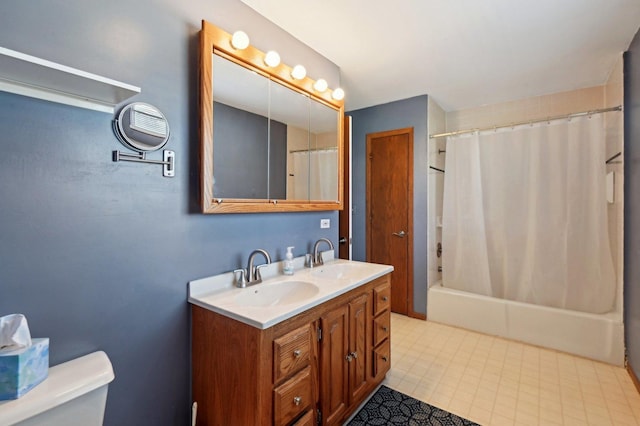 bathroom featuring double vanity, toilet, a sink, and shower / bath combo