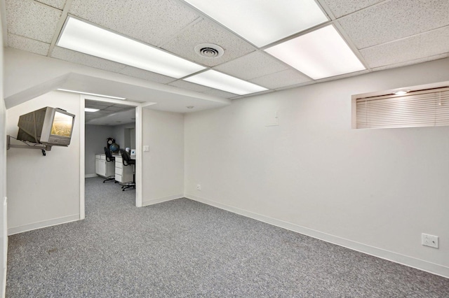 finished below grade area with baseboards, carpet, a paneled ceiling, and visible vents