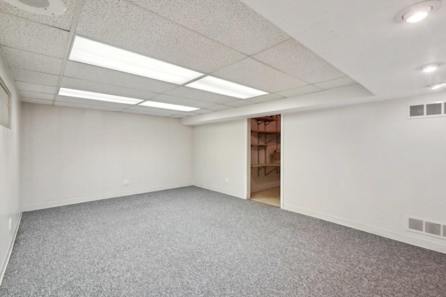 finished basement with carpet flooring, baseboards, visible vents, and a paneled ceiling