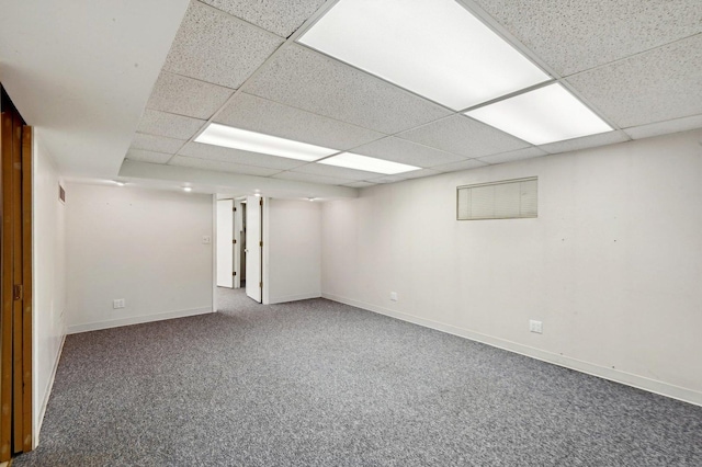 finished below grade area featuring baseboards, a drop ceiling, and carpet flooring