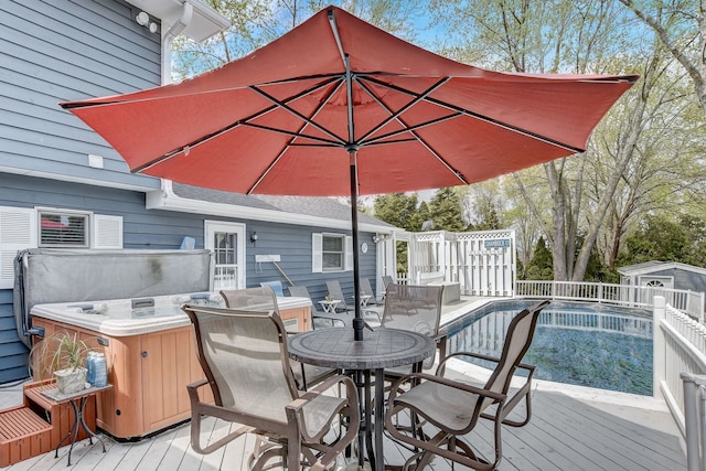 deck featuring a hot tub and outdoor dining space