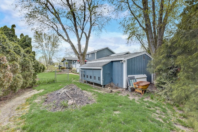view of yard with an outbuilding, fence, and a storage shed