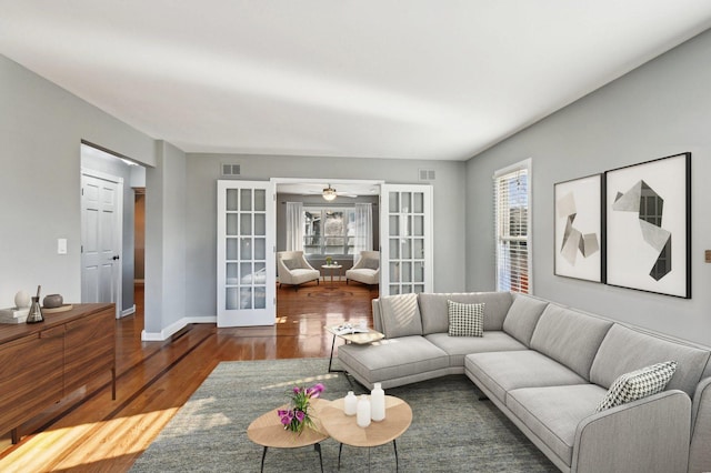 living room with french doors, plenty of natural light, wood finished floors, and visible vents