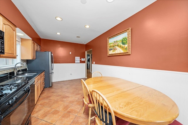 kitchen featuring a sink, black gas range oven, wainscoting, and recessed lighting