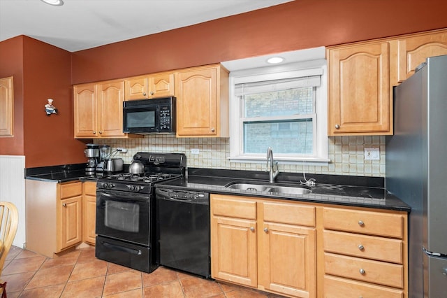 kitchen with dark countertops, a sink, and black appliances