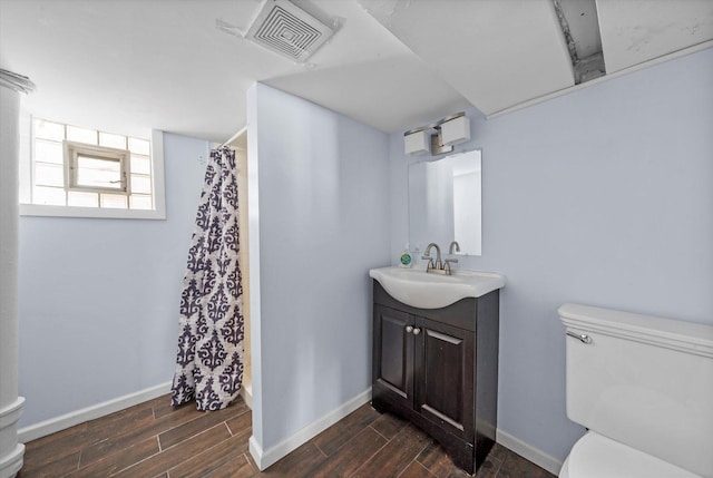 bathroom featuring visible vents, baseboards, wood finished floors, and toilet