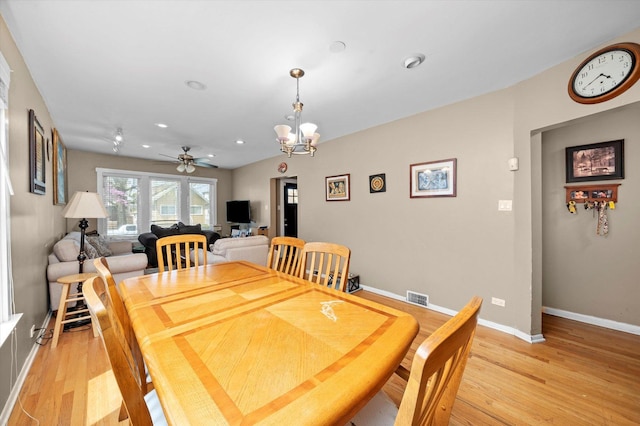 dining area featuring light wood finished floors, ceiling fan with notable chandelier, recessed lighting, baseboards, and visible vents