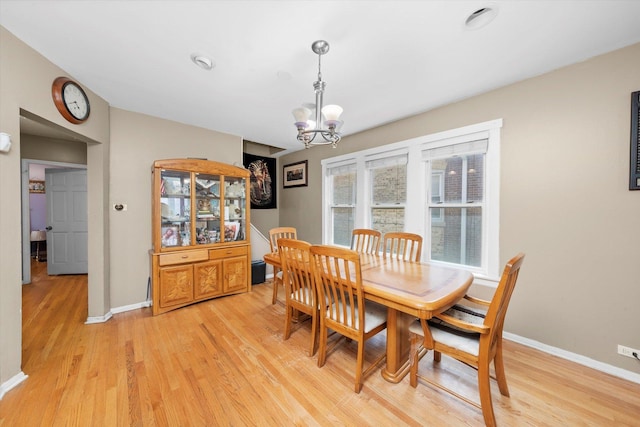 dining area with an inviting chandelier, baseboards, and light wood finished floors
