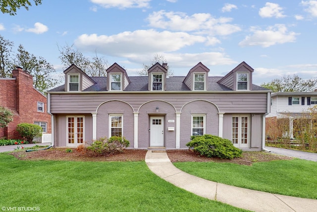 new england style home with french doors and a front yard