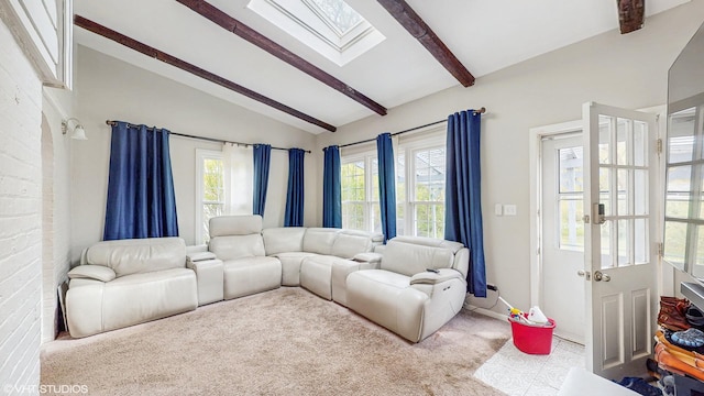 carpeted living room with lofted ceiling with skylight