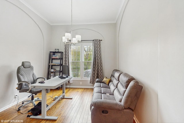 office with baseboards, a notable chandelier, ornamental molding, and light wood finished floors