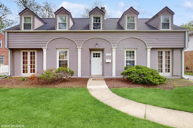 cape cod house featuring a front lawn, french doors, and a chimney