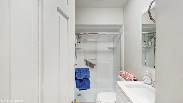 bathroom featuring vanity, toilet, and a stall shower