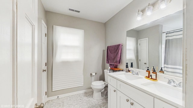 full bath featuring a sink, toilet, double vanity, and visible vents