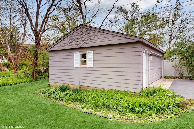 exterior space featuring a lawn, an outdoor structure, concrete driveway, and a garage
