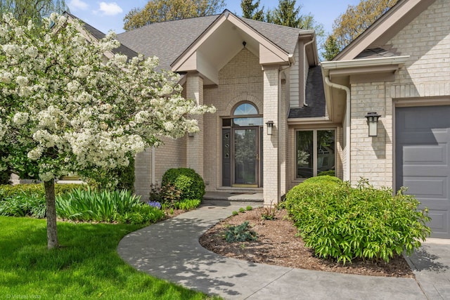 396 Crestwood Rd, Wood Dale, IL 60191 - doorway to property with a shingled roof, brick siding, and an attached garage