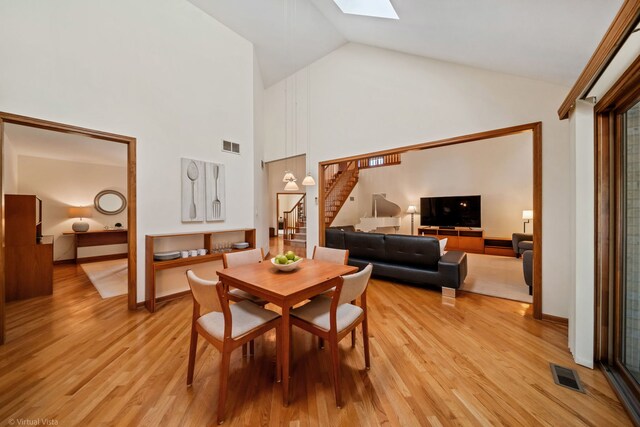 396 Crestwood Rd, Wood Dale, IL 60191 - dining area featuring stairs, light wood finished floors, high vaulted ceiling, and a skylight