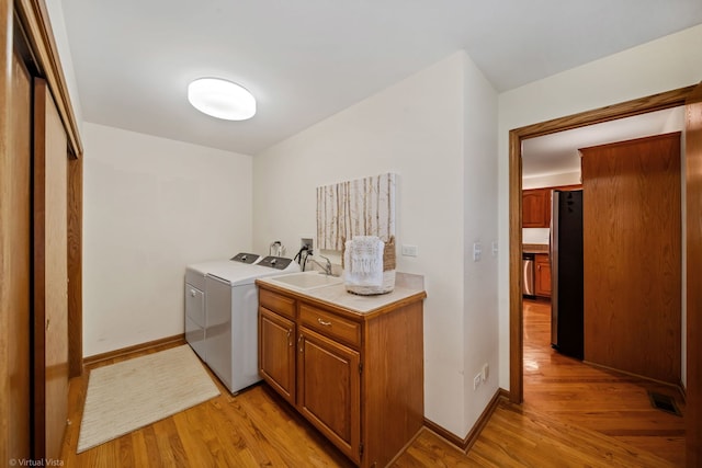 396 Crestwood Rd, Wood Dale, IL 60191 - laundry room with cabinet space, light wood-style flooring, washer and clothes dryer, and baseboards