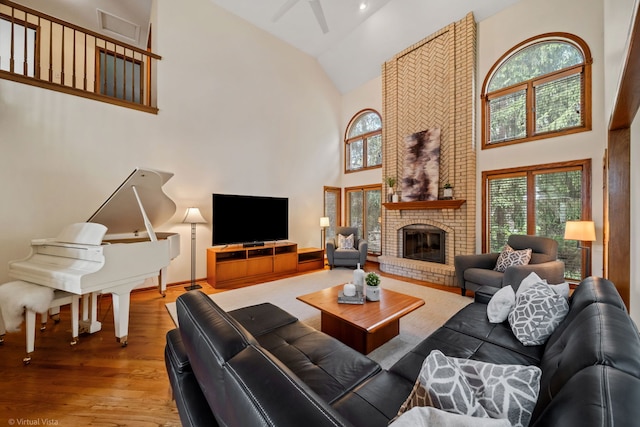 396 Crestwood Rd, Wood Dale, IL 60191 - living area featuring high vaulted ceiling, wood finished floors, a ceiling fan, a fireplace, and plenty of natural light