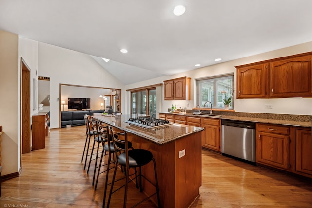 396 Crestwood Rd, Wood Dale, IL 60191 - kitchen with appliances with stainless steel finishes, a sink, a kitchen island, a breakfast bar, and light wood-style floors