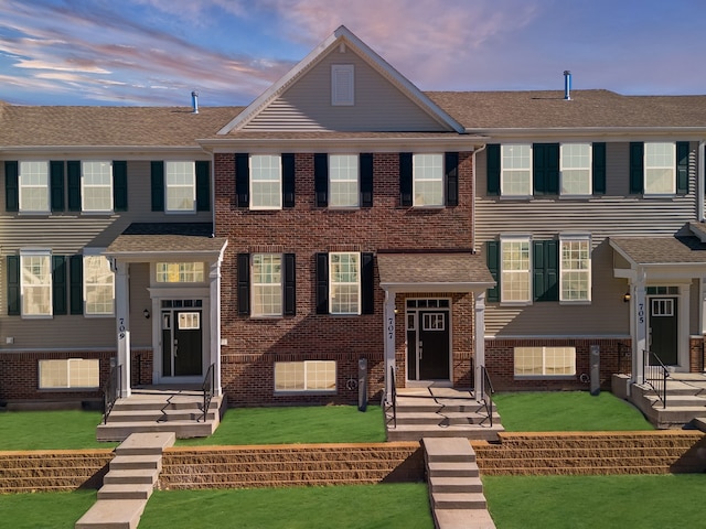 3705 Neubauer Cir Unit 103, Lindenhurst, IL 60046 - view of front facade with brick siding, a yard, and roof with shingles