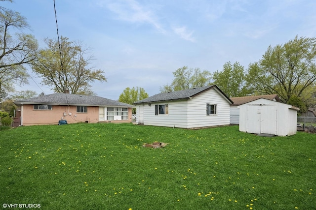 back of house with a lawn, a shed, and an outbuilding