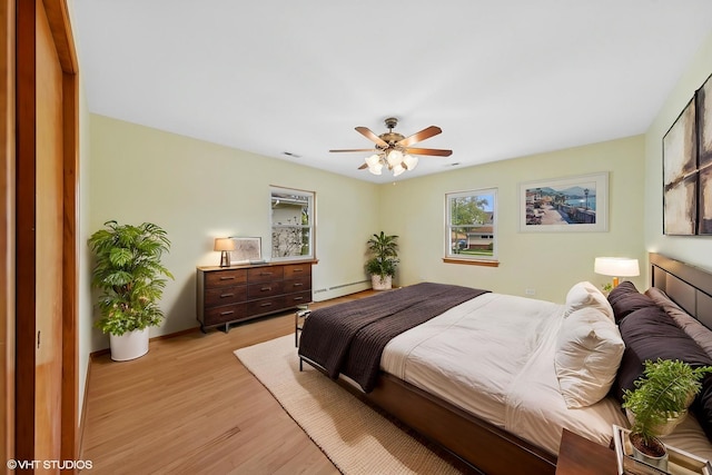 7010 W Devon Ave, Chicago, IL 60631 - bedroom with baseboard heating, light wood-type flooring, and a ceiling fan