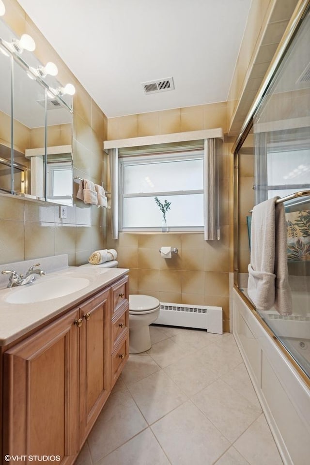 7010 W Devon Ave, Chicago, IL 60631 - bathroom with baseboard heating, vanity, tile walls, tile patterned floors, and toilet