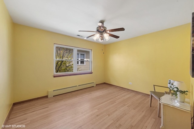 7010 W Devon Ave, Chicago, IL 60631 - spare room with a baseboard radiator, a ceiling fan, light wood-style floors, and baseboards