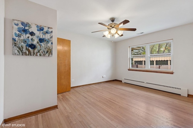 7010 W Devon Ave, Chicago, IL 60631 - spare room featuring a baseboard radiator, wood finished floors, baseboards, and a ceiling fan