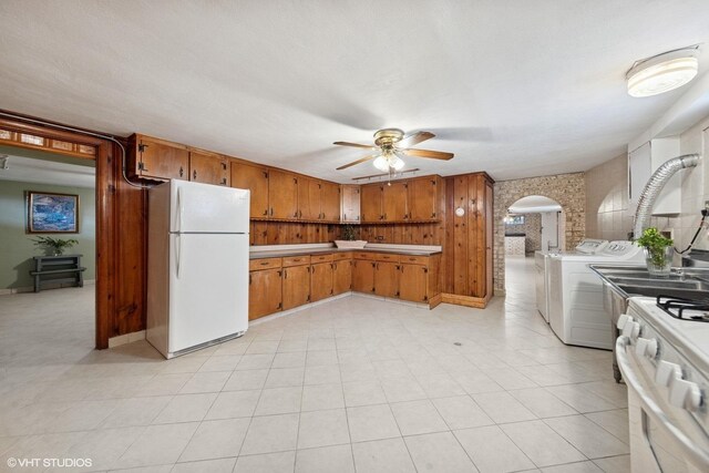 7010 W Devon Ave, Chicago, IL 60631 - kitchen featuring white appliances, separate washer and dryer, ceiling fan, arched walkways, and brown cabinetry