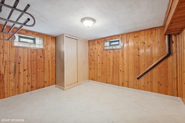 7010 W Devon Ave, Chicago, IL 60631 - basement featuring tile patterned floors, wooden walls, and healthy amount of natural light