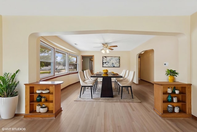 7010 W Devon Ave, Chicago, IL 60631 - dining space featuring arched walkways, light wood-style floors, ceiling fan, and baseboards