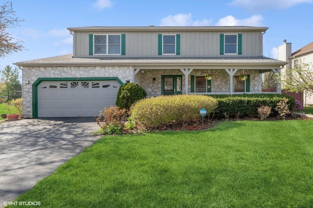 traditional-style home with a porch, a front yard, driveway, and stone siding