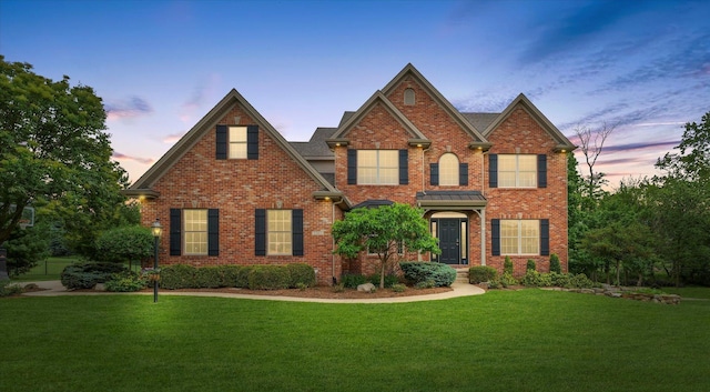 view of front facade with a front yard and brick siding