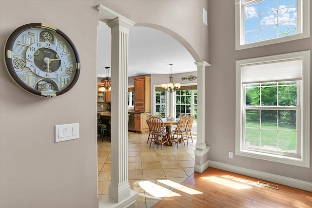 dining space with decorative columns, healthy amount of natural light, baseboards, and arched walkways