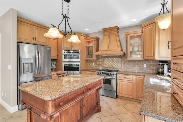kitchen with appliances with stainless steel finishes, premium range hood, a sink, a kitchen island, and light stone counters