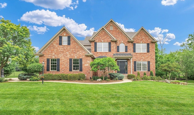 view of front of house with a front lawn and brick siding