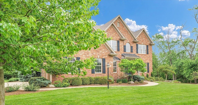 view of front of property with brick siding and a front lawn