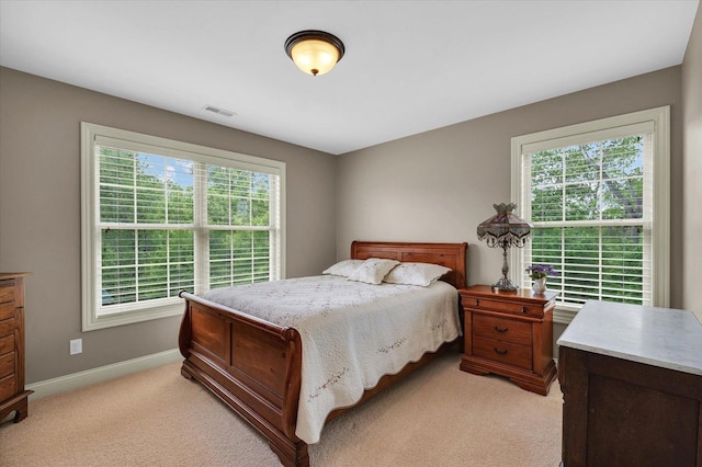 bedroom with light carpet and baseboards