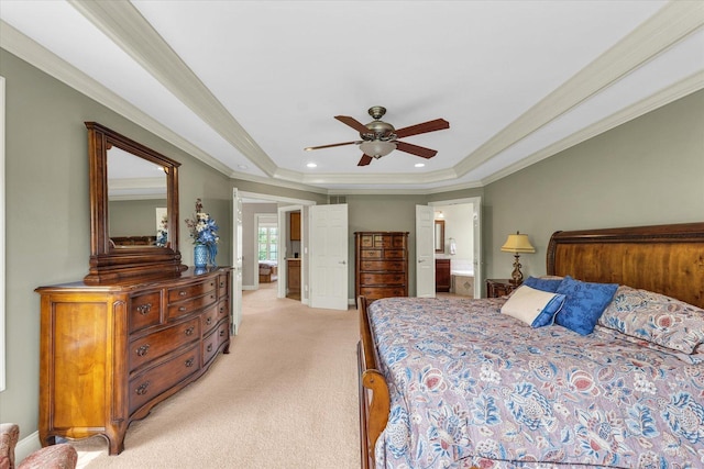 bedroom with a tray ceiling, light carpet, crown molding, ceiling fan, and connected bathroom