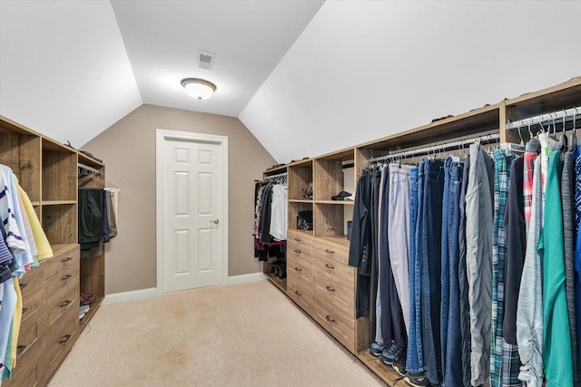 walk in closet with light colored carpet and lofted ceiling
